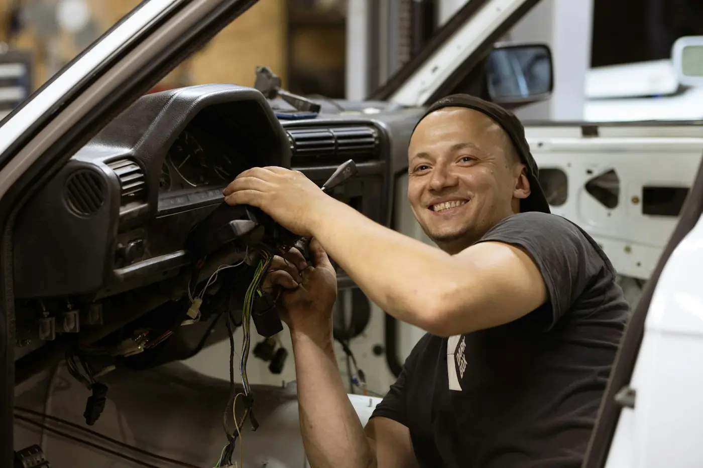 Technicien installant un boîtier sous le tableau de bord d'un véhicule